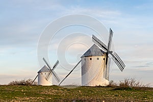 Two whitewashed traditional Spanish windmills on the plains of La Mancha