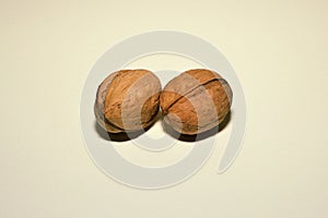Two whole walnuts on a white background