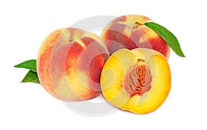 Two whole and a half peaches with green leaves (isolated)