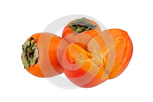 Two whole orange persimmons fruits or diospyros kaki and one persimmon sliced in half on white background isolated closeup