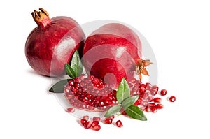 Two whole and part of a pomegranate with pomegranate seeds
