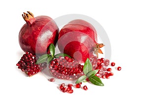 Two whole and part of a pomegranate with pomegranate seeds photo