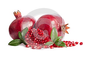 Two whole and part of a pomegranate with pomegranate seeds