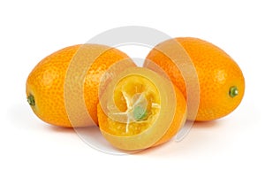 Two whole and sliced kumquat fruits