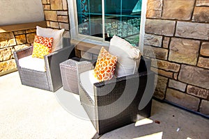 Two Wicker Arm Chairs And Table On Front Porch