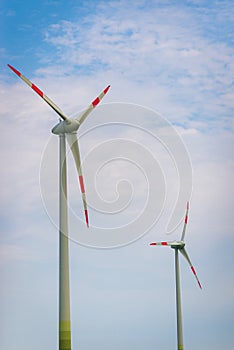 Two Wind turbines with blue sky background summer day.An environmentally friendly way to get electricity