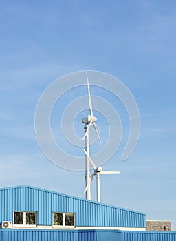 Two wind turbines in the blue sky with copy space.
