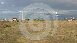 Two wind turbines drone shot under grey sky