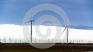 Two wind turbines in the field on stormy day