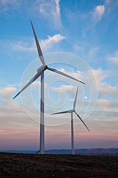 Two wind turbines at sunset