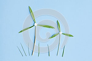 Two windmills made of fresh green leaves on blue