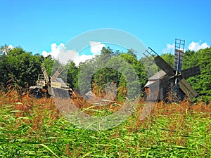 two windmills,traditional Romanian,at the edge of the forest