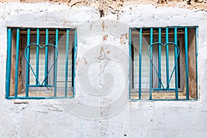 Two windows with blue metal bars in shape of heart