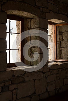 Two windows on a brick wall inside a dark construction
