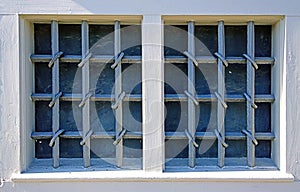Two windows closed by wrought iron grates