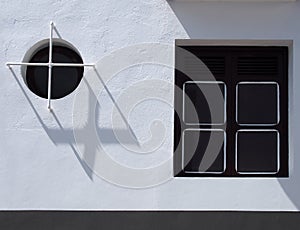 Two windows in modern house square and round with stell bars and