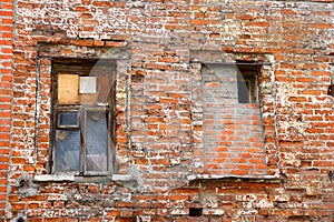 Two windows in an old brick wall, broken red bricks, red brick background