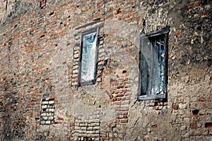 Two windows in red brick wall building in weird diagonal placement