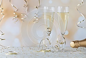 Two wine flutes filled with champagne with a wedding ring in one of them. Engagement concept.