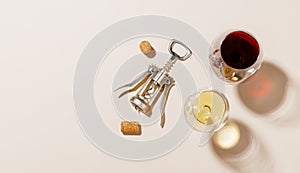 Two wine glasses alongside a corkscrew and several corks