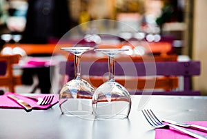 Two wine glasses and cutlery on table in restaurant