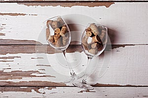 Two, wine glasses, filled, corks, wine bottles, wooden background
