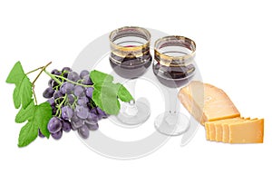 Two wine glasses with red wine, cheese and blue grape