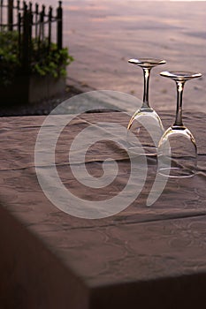 Two wine glasses on a table at sunet
