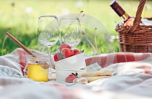 Two wine goblets, fresh strawberry, honey and wine are served for summer romantic picnic