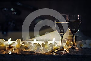 Two wineglasses with flowers and candles