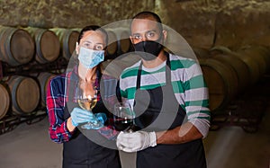 Two winemakers posing with wine in glasses