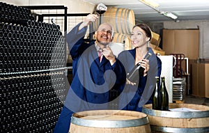 Two winery workers holding glass of wine