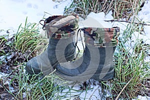 Two winter boots made of green rubber and spotted fabric