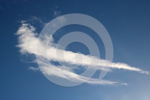 Two wispy white clouds in blue sky