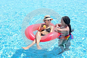 Two woman enjoying in swimming pool. Summer holiday idyllic. Summer vacation concept