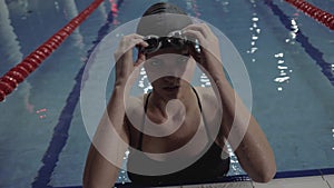 Two woman friends in chiffon dress swimming together underwater on dark background