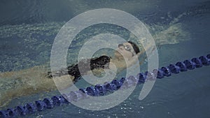 Two woman friends in chiffon dress swimming together underwater on dark background