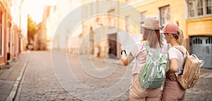 Two woman looking for the location of sights on the map of old Tallinn, Estonia.