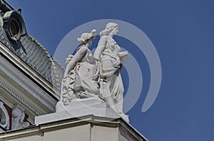 Two woman sculpture on top pf building