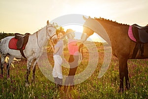 Two woman and two horses outdoor in summer happy sunset together nature
