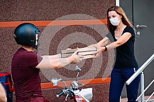 Two womans pick up delivery food box from delivery rider with scooter in front house for social distancing for infection