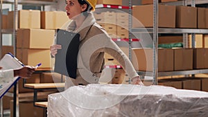 Two women analyzing list of products in warehouse