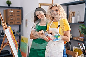 Two women artists smiling confident drawing at art studio