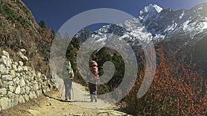 Two women backpacker trekking on himalaya mountain trail. Sagarmatha national park, EBC, Nepal. View to snowy mountains