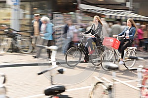 Two women bike to work in Amsterdam City Traffic.