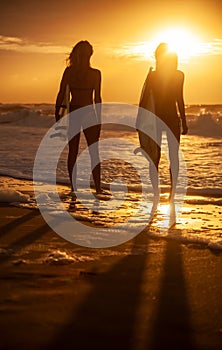 Two Women Bikini Surfers With Surfboard Sunset or Sunrise Beach