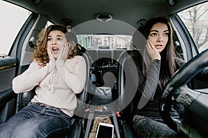 Two women bracing for a car crash accident. Two girls shocked drive car