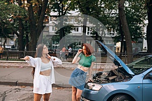 Two women with broken car road look for help.