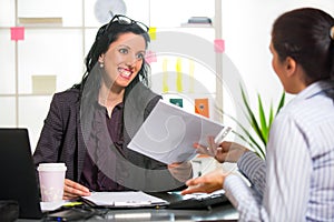 Two women chat to each other in the office.