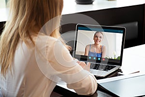 Two women chatting online by making video call on laptop